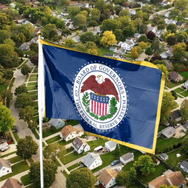 The Federal Reserve Board of Governors flag and an aerial view of houses