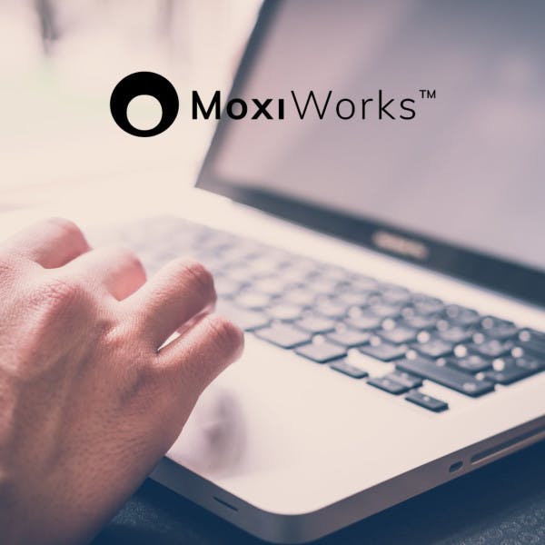 MoxiWorks logo and a closeup of hands typing on a laptop