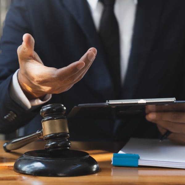 A lawyer reaches out his hand requesting his fees.