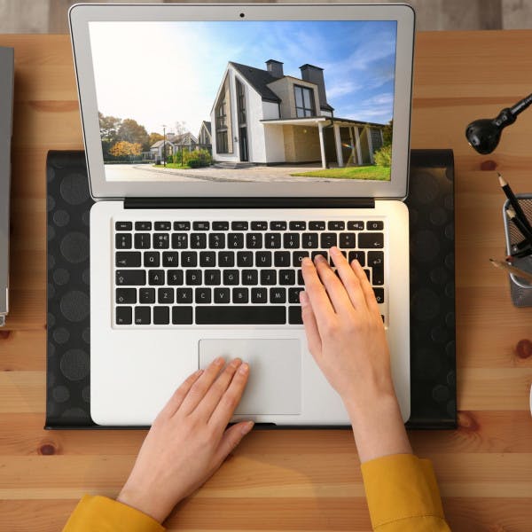 A woman navigates to a real estate website on her laptop