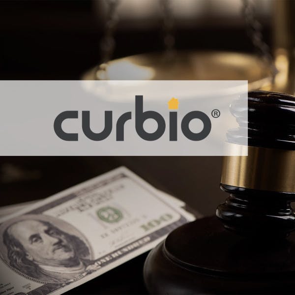 Curbio logo and a judge's gavel next to a pile of hundred-dollar bills