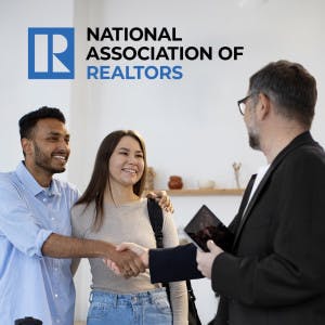 The National Association of Realtors logo and a real estate agent shaking hands with a couple looking at a house