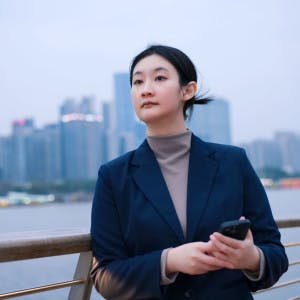 Businesswoman looking uncertain with city skyline in the background