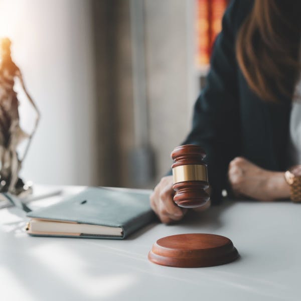 A female judge in her chambers with gavel and scales of justice