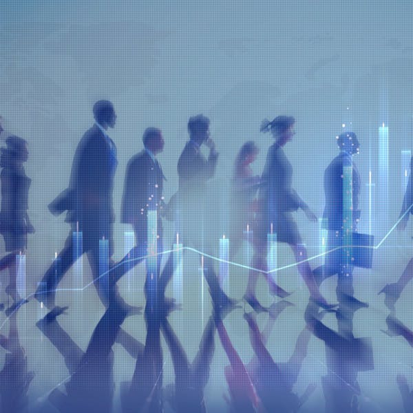 Silhouettes of business people walking and an overlay of a financial chart.