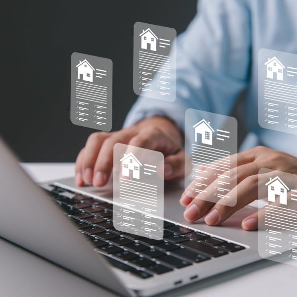 A real estate agent enters property data on a laptop