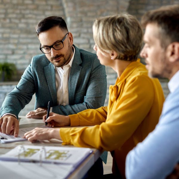 A real estate agent reviews a contract with clients